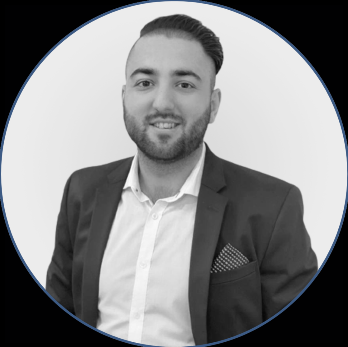 Headshot of a smiling man in a suit and white shirt against a plain background